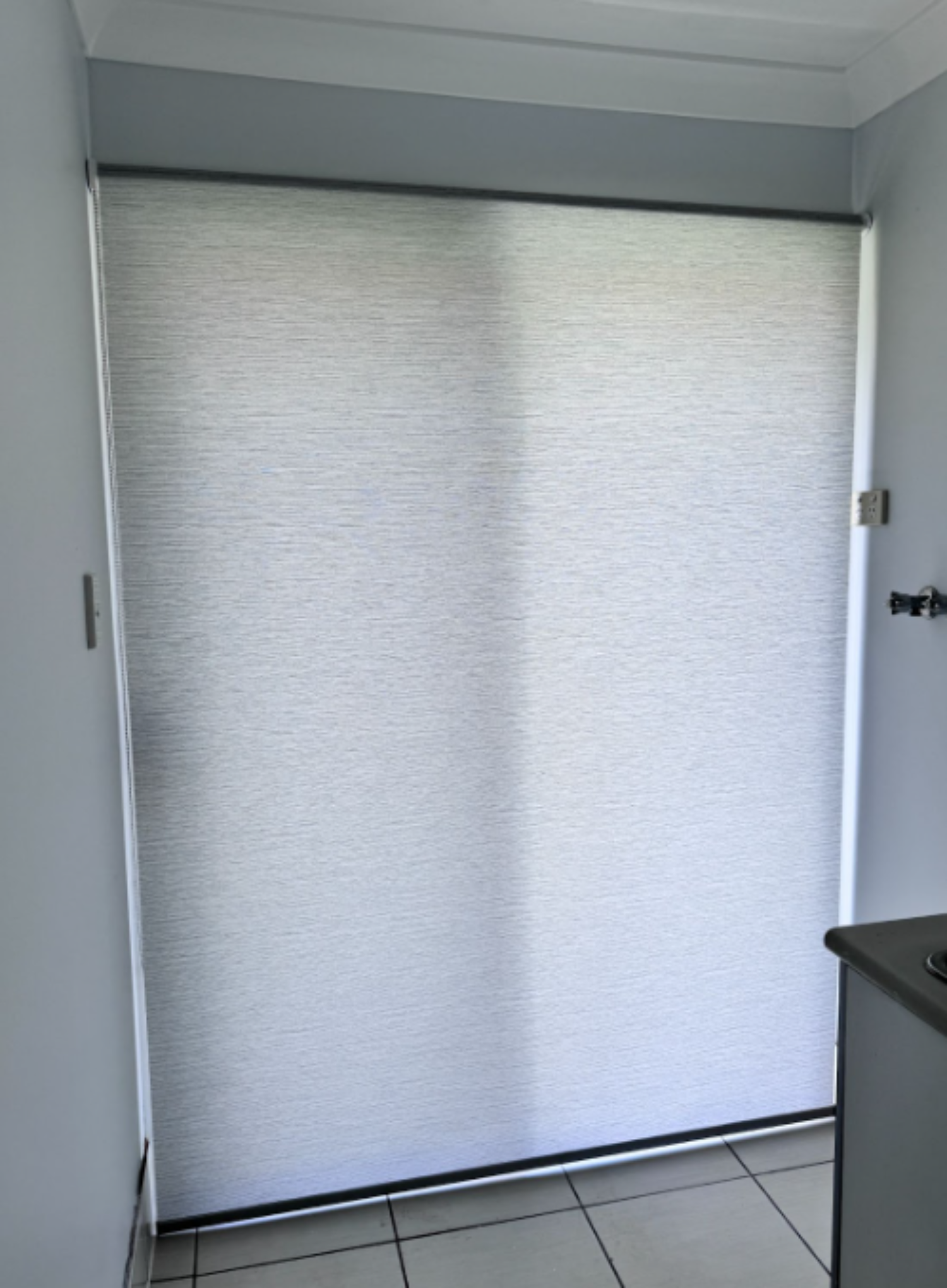 White light filtering privacy roller blind installed on sliding door of laundry