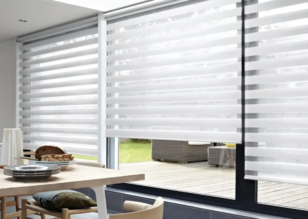 Dual day-and-night roller blind combining a sheer and a blockout layer