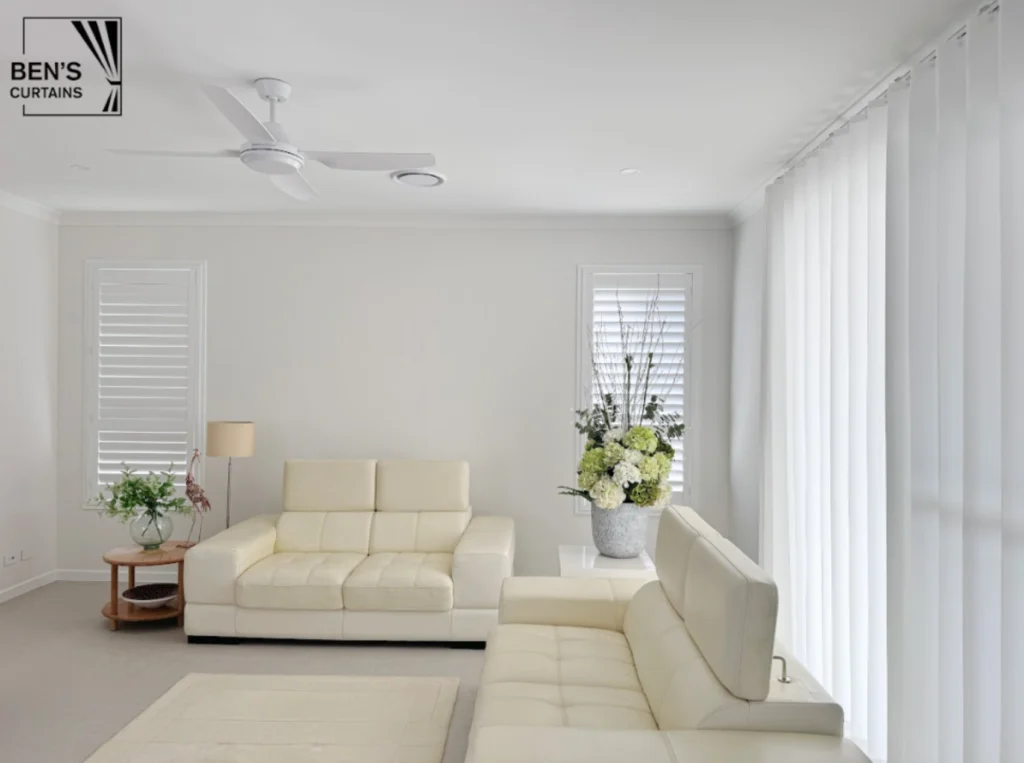 Plantation shutters and vertical blinds installed in a bright Auckland living room
